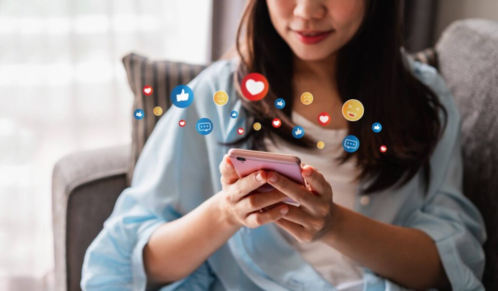 Instagram Stories reposten, Mädchen mit einem Smartphone über dem Social Media Icons schweben