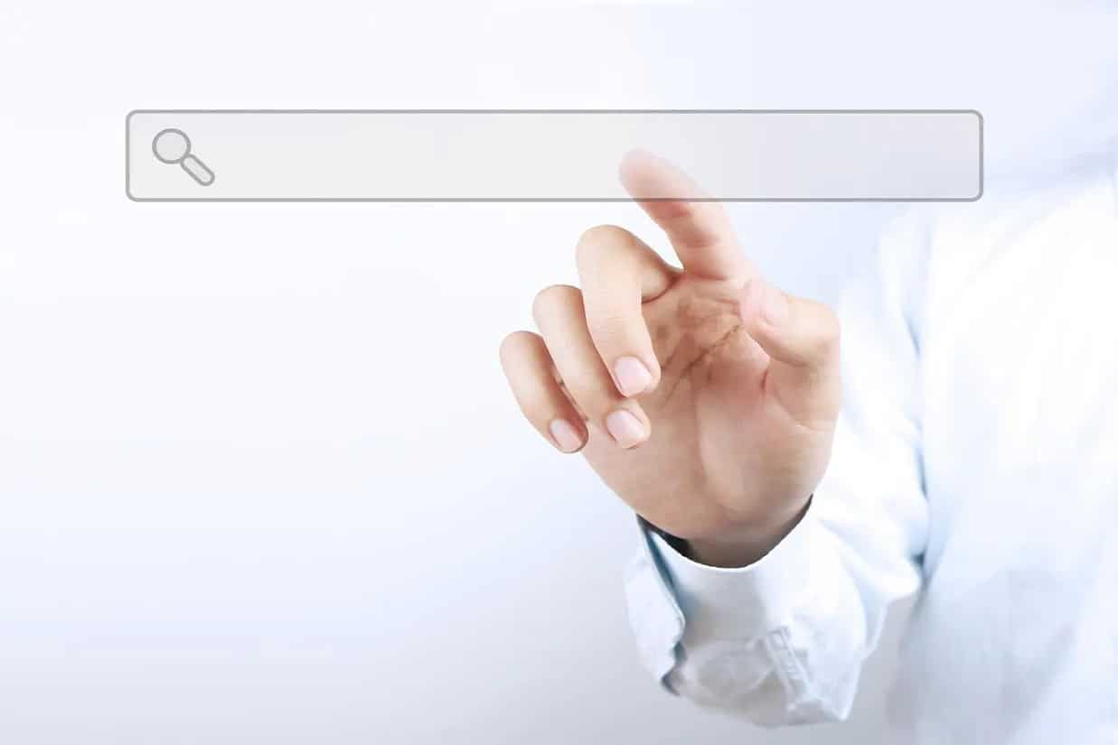 Suchmaschinen Platzierung - Nahaufnahme einer Hand die auf eine Suchleistengrafik tippt.