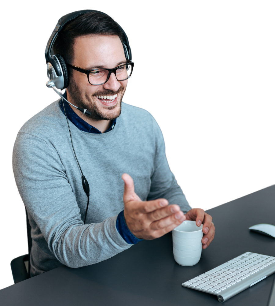 Ein Mann sitzt am Schreibtisch und telefoniert mit einem Headset.