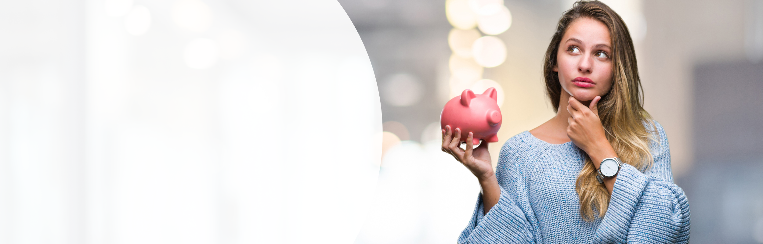 Frau in einem blauen Pullover mit nachdenklichem Gesichtsausdruck hält ein Sparschwein in ihrer Hand.