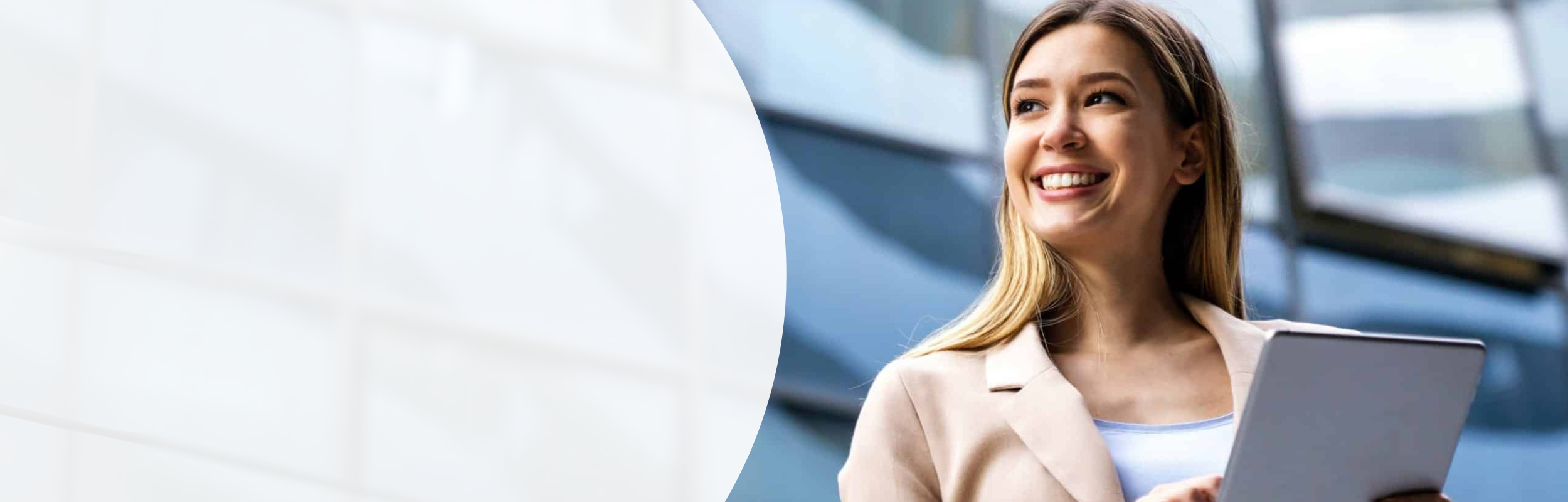 Eine Frau im rosa Jacket hält ein Tablet in der Hand