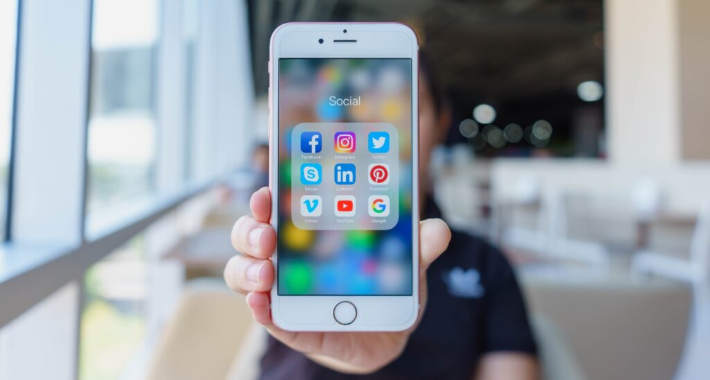 ein weißes Smartphone, das die App-Icons von verschiedenen Social Media Kanälen zeigt